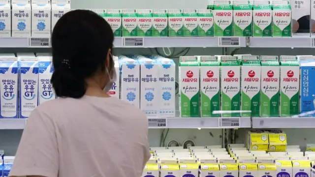 마트 우유 진열대 앞에 서있는 여자