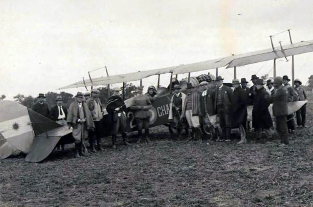 Um avião antigo rodeado por pessoas