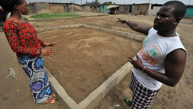 Noura Dosso (G) et Youssouf, se tiennent près d'une fosse commune où ont été enterrés les corps d'une trentaine de personnes qui auraient été tuées le 12 avril 2011 par des miliciens pro-Gbagbo, dans le quartier populaire de Yopougon à Abidjan, le 5 décembre 2011