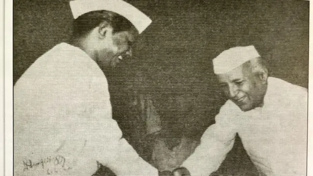 ప్రధానమంత్రి జవహర్ లాల్ నెహ్రూతో కరచాలనం చేస్తూ..