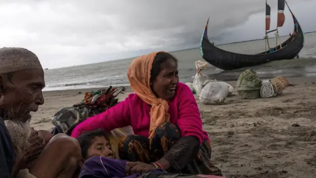 Rohingya refugees comfort an elderly woman, after the wooden boat they were travelling on from Myanmar, crashed into the shore and tipped everyone out on September 12, 2017 in Dakhinpara, Bangladesh.