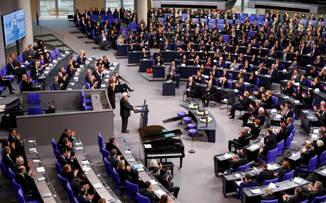 في برلين، تحدث كلاوس شردوان (أعلاه وأدناه)، ممثل مجتمع المثليين، خلال حفل تذكاري لإحياء ذكرى ضحايا الهولوكوست في مجلس النواب الألماني (البوندستاغ).