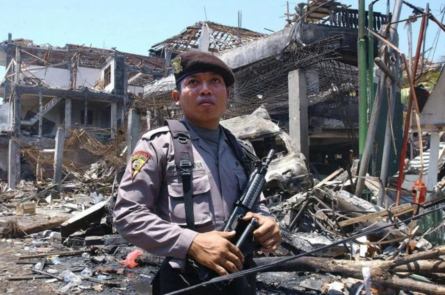 ตำรวจยืนอยู่หน้าซากอาคารที่ถูกวางระเบิดบนเกาะบาหลี เมื่อปี 2002 ซึ่งทำให้มีผู้เสียชีวิตกว่า 200 คน