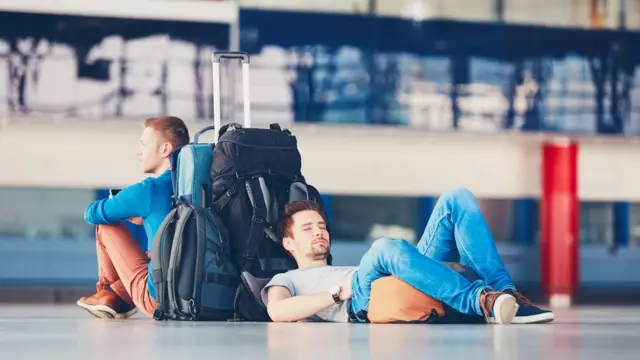 Pasajeros esperando en aeropuerto.