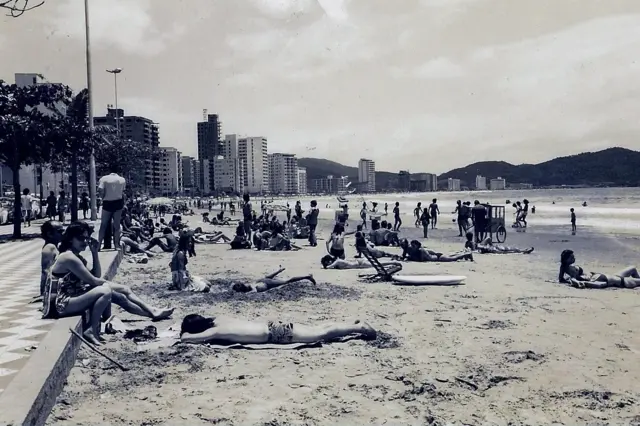 Imagem de uma praia em preto em branco com prédios altos