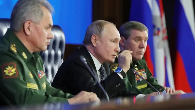 O presidente Vladimir Putin (ao centro) e o ministro da defesa russo Sergei Shoigu (à esquerda) participambetesporte como funcionareunião anual do conselho do Ministério da Defesa.