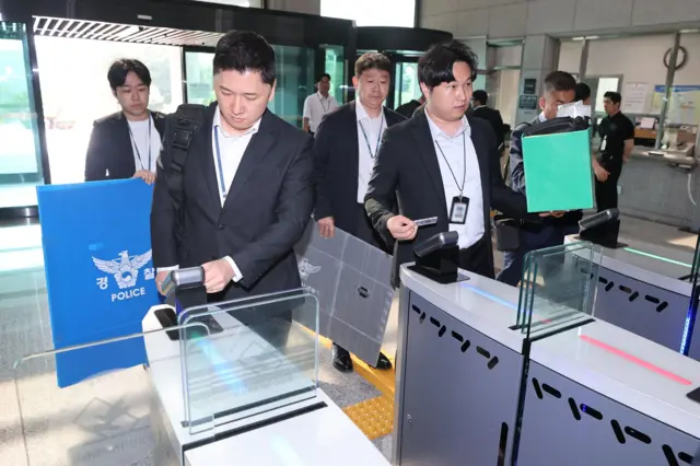 2026년 6월 11일 경기도 과천시 중앙선거관리위원회 청사로 경찰 수사관들이 들어가고 있다. 경찰은 6월 3일 지방선거 당시 26개 투표소에서 투표가 중단된 투표용지 부족 사태와 관련한 수사의 일환으로 압수수색을 실시했다.