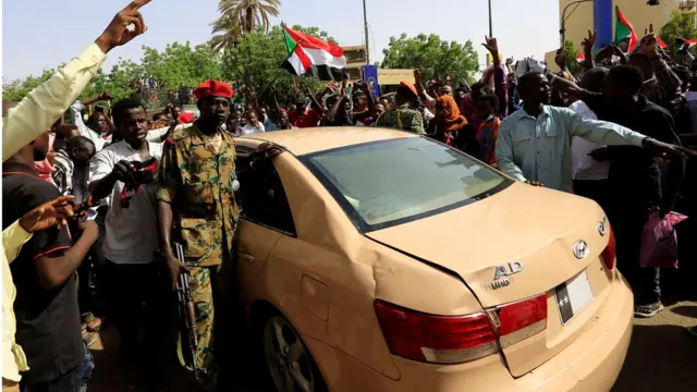 محتجون يحيطون بسيارة أحد الضباط، ويرددون هتافات غاضبة بعد بيان الجيش.