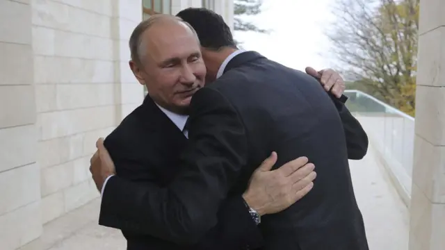 Putin ile Esad sarılıyor.