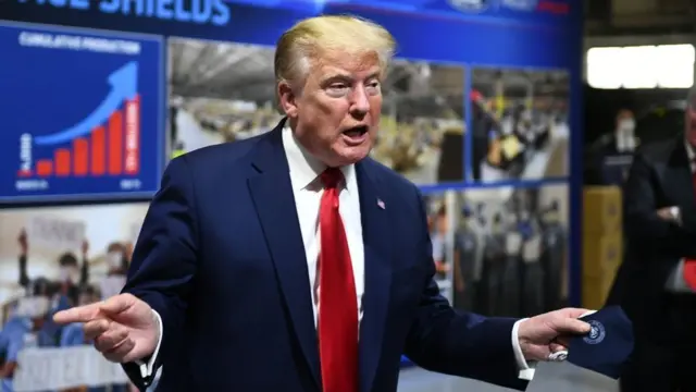 Trump holding a mask with a presidential seal