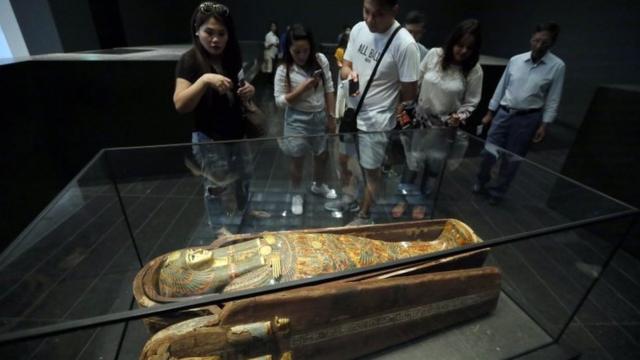 Visitantes olham para múmia no Louvre, em Paris