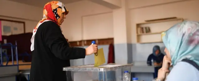 Женщина голосует на участке в Стамбуле