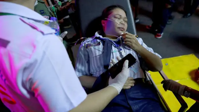 A woman is seen on a stretcher after the Central World Complex was evacuated due to a fire, in Bangkok, Thailand, April 10, 2019. REUTERS
