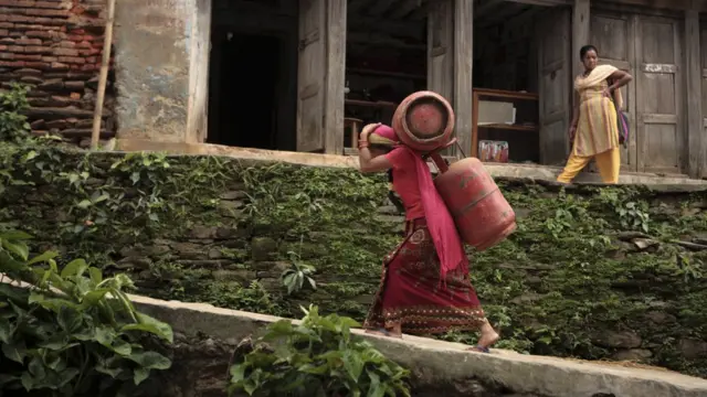 గ్యాస్ సిలిండర్లు తీసుకెళ్తున్న మహిళ