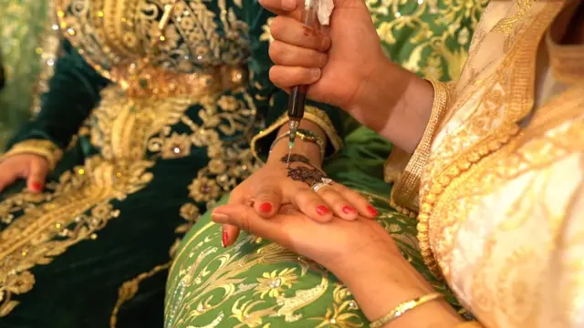 امرأة ترسم الحنّة على يد عرو