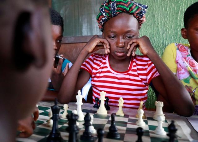 فتاة تفكر في حركة شطرنج