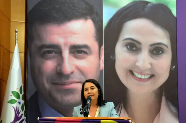Serpil Kemalbay, HDP'nin tutuklu liderleri Selahattin Demirtaş ve Figen Yüksekdağ'ın fotoğrafları önünde konuşurken