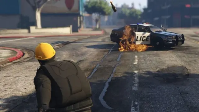 Seorang pengunjuk rasa melemparkan bom molotov ke mobil polisi di dalam gim GTA V.