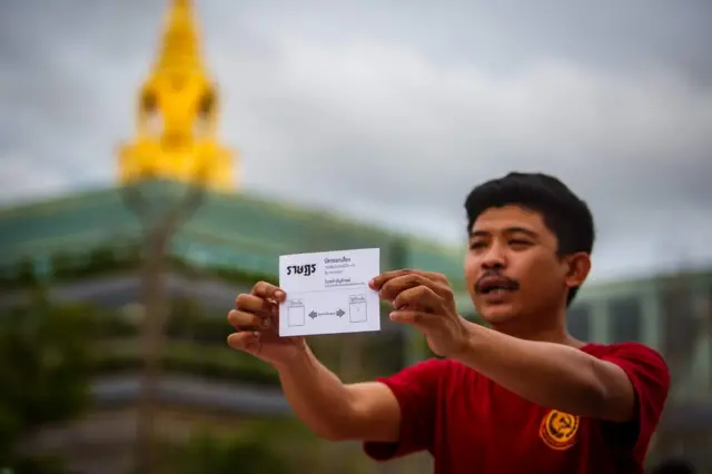 ประชาชนผู้เกาะติดศึกอภิปรายบริเวณหน้ารัฐสภาโชว์บัตรลงคะแนนไม่ไว้วางใจของแนวร่วม "ราษฎร"