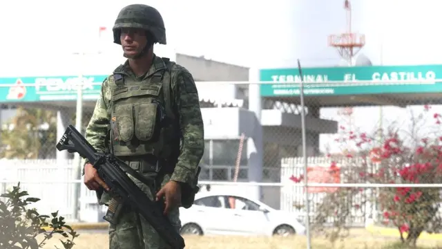 Militar de guardia frente a una gasolinera.