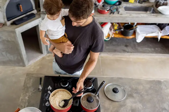 Fotobets betanobancobets betanoimagens mostra homem cozinhando com criança no colo