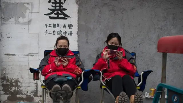 فتيات في الصين يستخدمن هواتف محمولة