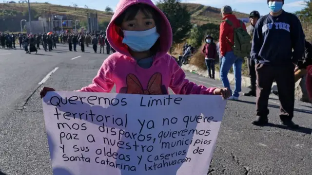 Una niña porta un cartel en una protesta en Ixtahuacán
