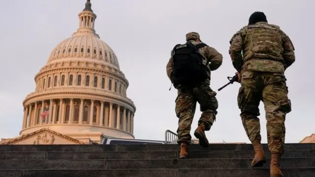 National Guard members walk at the Capitol in Washington on January 15, 2021
