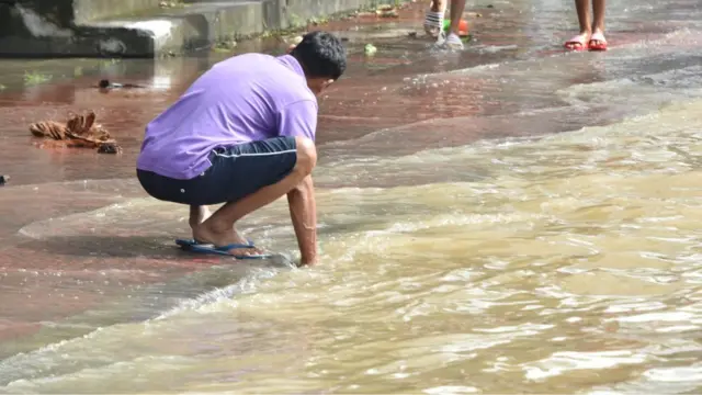 ชายนั่งอยู่ริมถนนในตัวเมืองนครศรีธรรมราช