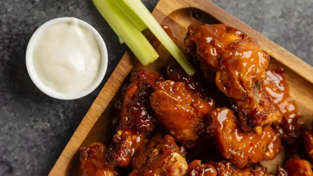 Мясо в соусе, соус в миске и черешки сельдерея