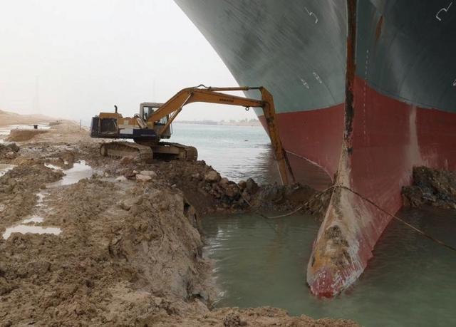岸上的挖掘機負責清理船頭周圍的沙石泥土