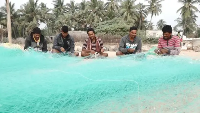 వలను సిద్ధం చేస్తున్న జాలర్లు