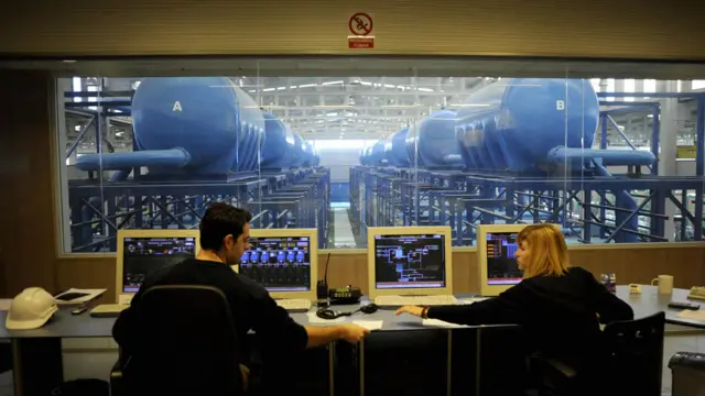 Dos personas en la sala de control de una planta de desalinización