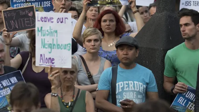 'Müslüman komşuma dokunma' dövizi taşıyan bir kadın.