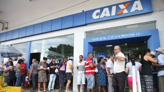 Pessoascodigo promocional brazinopé, formando uma fila,codigo promocional brazinofrente a uma agência da Caixa