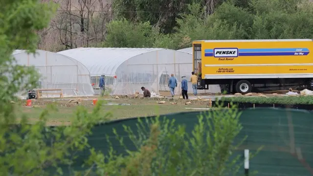A group of Chinese immigrant workers unload tools from a truck to build hoop houses on a cannabis farm in Shiprock, New Mexico