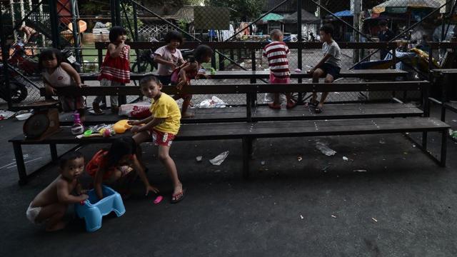 เด็กในชุมชนกำลังนั่งเล่นกันภายในลานกีฬาใต้ทางด่วน