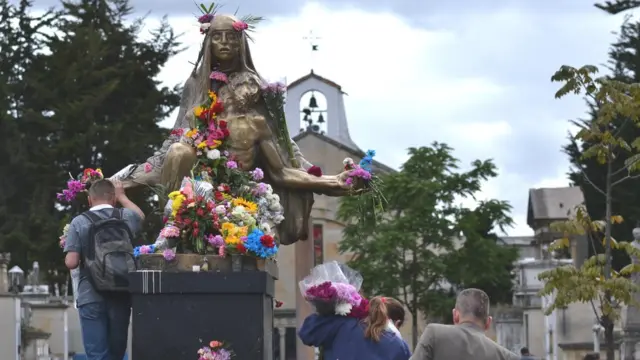 Fieles frente a la estatua de La Piedad