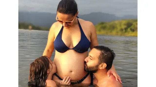 Carolina Ribeiro, grávida, junto com o marido e a filha