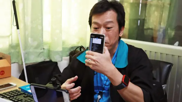 นายสิทธิโชค วรอิทธินันท์ ใช้มือจับโทรศัพท์มือถือ โชว์เข้าหากล้อง ขณะกำลังถ่ายทอดสดรายการ 'โชว์โนอาย'