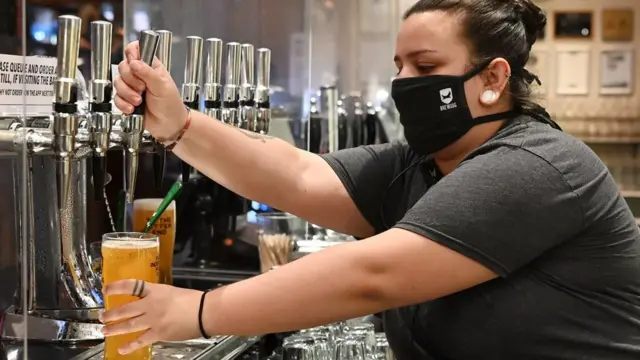 женщина-бармен наливает пиво