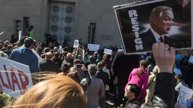Con carteles que dicen "mentiroso" y "renuncia", un grupo de manifestantes exigen la partida de Jeff Sessions frente al Departamento de Justicia en Washington D.C.