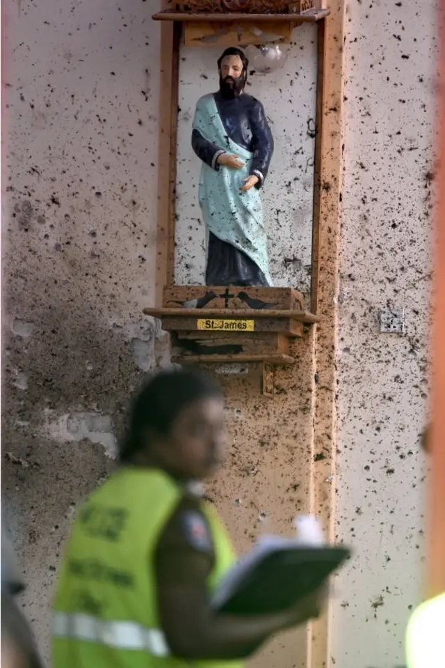 A security personnel inspects inside St Sebastian's Church in Negombo on April 22, 2019, a day after the church was hit in series of bomb blasts targeting churches and luxury hotels in Sri Lanka. - The death toll from bomb blasts that ripped through churches and luxury hotels in Sri Lanka rose dramatically April 22 to 290 -- including dozens of foreigners -- as police announced new arrests over the country's worst attacks for more than a decade.