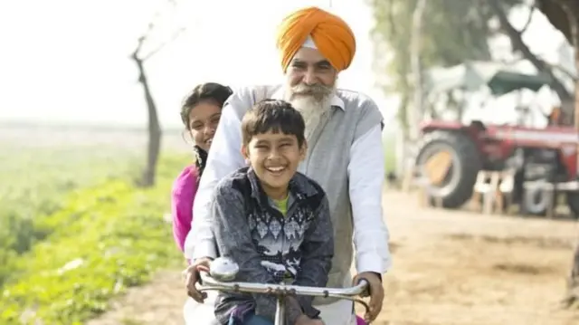 Homem velho com crianças em bicicleta
