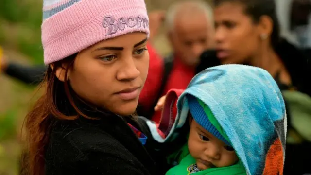 Mãe venezuelana com o filho na Colômbia