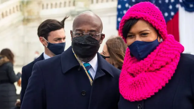 Raphael Warnock con su pareja y Jon Ossoff detrás