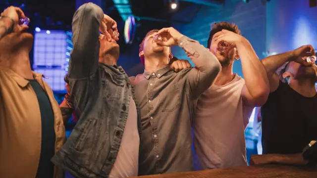 Un grupo de hombres tomando tragos.