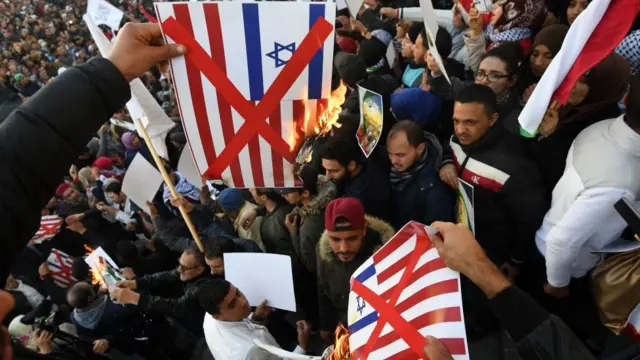 Tunisians burn posters bearing images of the US and Israeli flags during a demonstration on Habib Bourguiba Avenue in Tunis on December 8, 2017