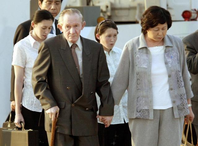 Hitomi leads her frail husband by the hand as their daughters walk behind at Tokyo international airport on 18 July, 2004