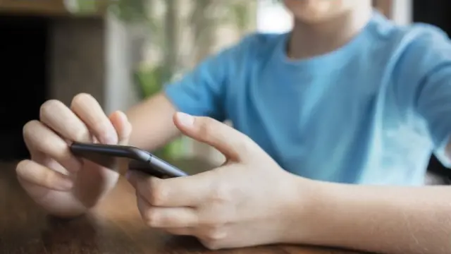 طفل ينظر إلى الهاتف